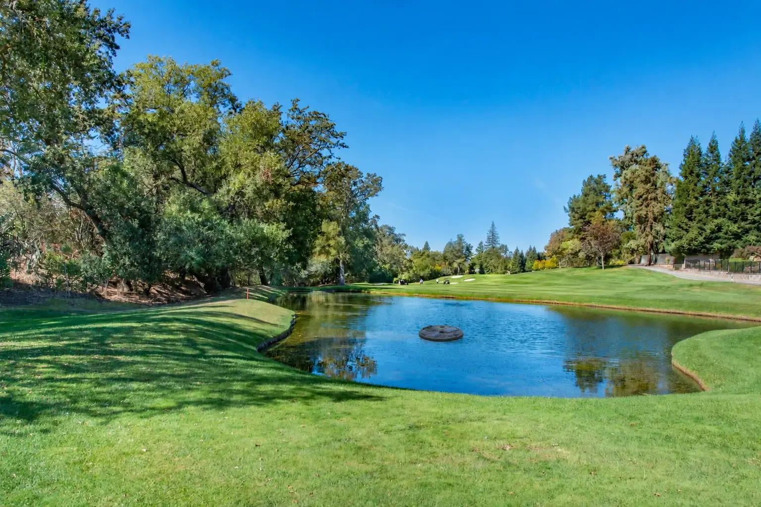 A Caddis MANTA autonomous water drone floating on a golf course pond