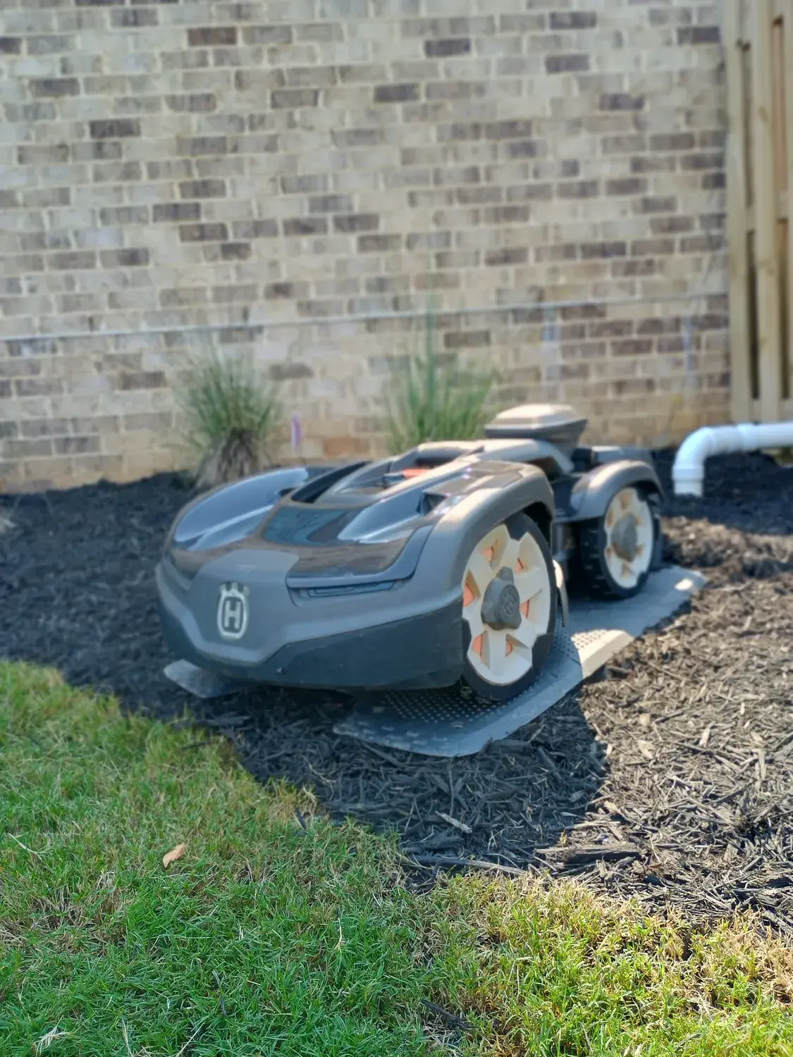 A Husqvarna all-wheel-drive Automower at its charging station on a Knoxville lawn